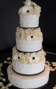 White buttercream iced, 4 tier round wedding cake decorated with a sporadic scroll work.  Fresh Flowers used as the topper and between separations of the tiers. 
(a colored table linen is used to direct your attention toward the cake)